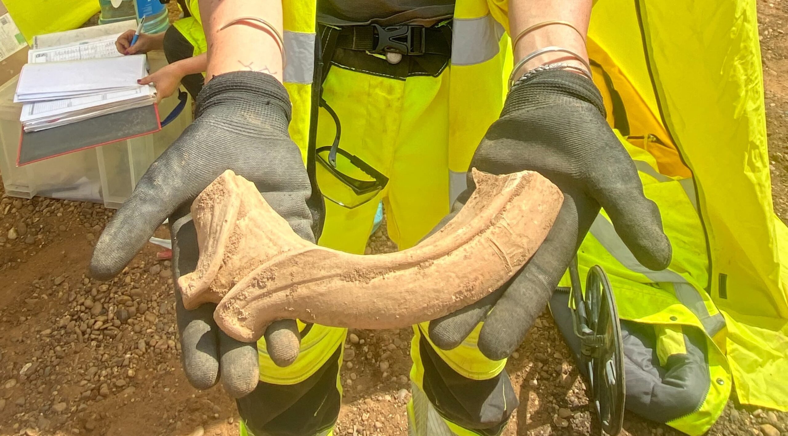Archaeologist showing a sherd of mortaria crop credit National Highways AMS scaled
