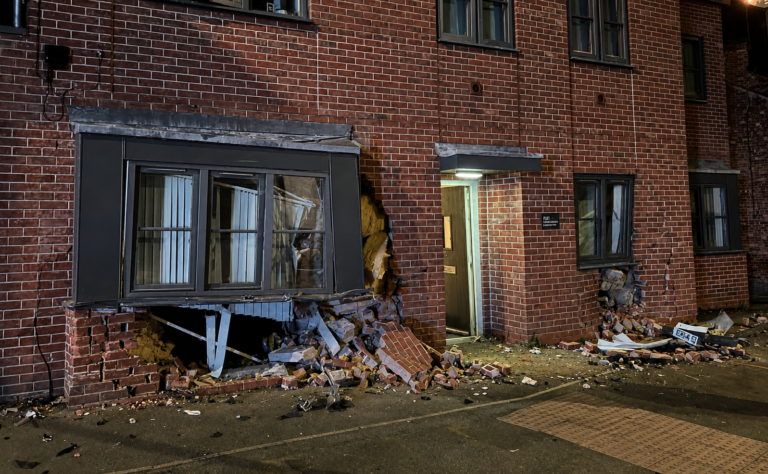 Flats evacuated after car crashes into window of residential property